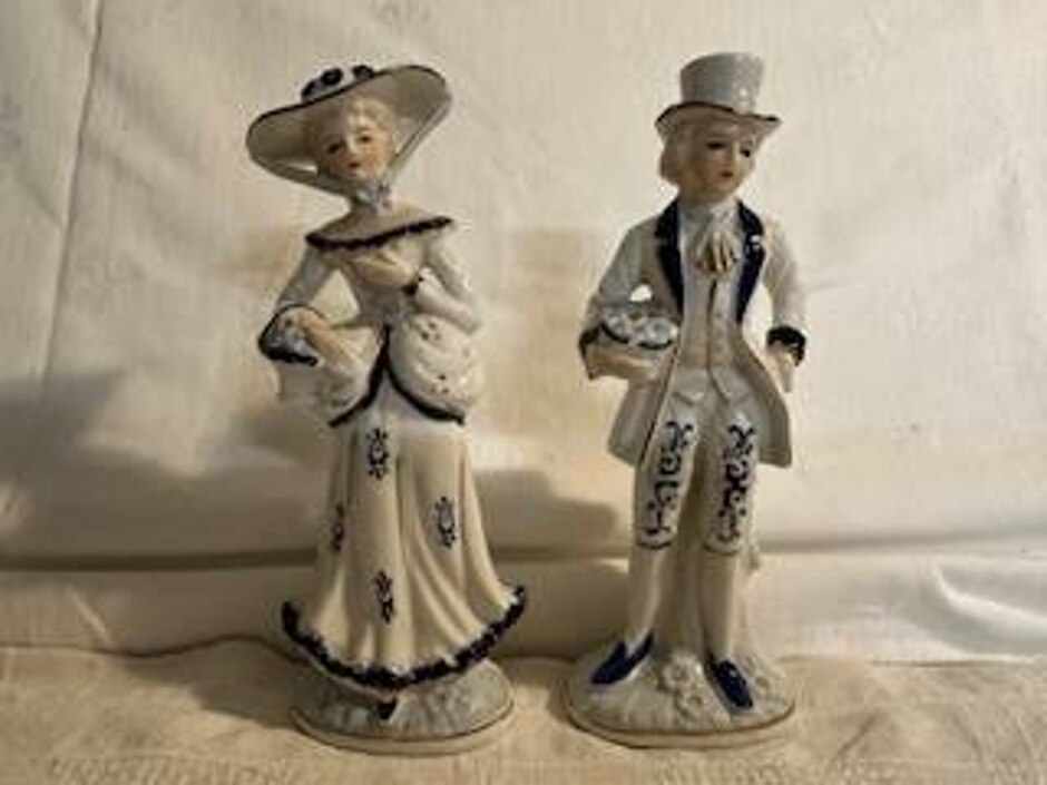 Two Figures Dressed In Old Fashioned Clothes