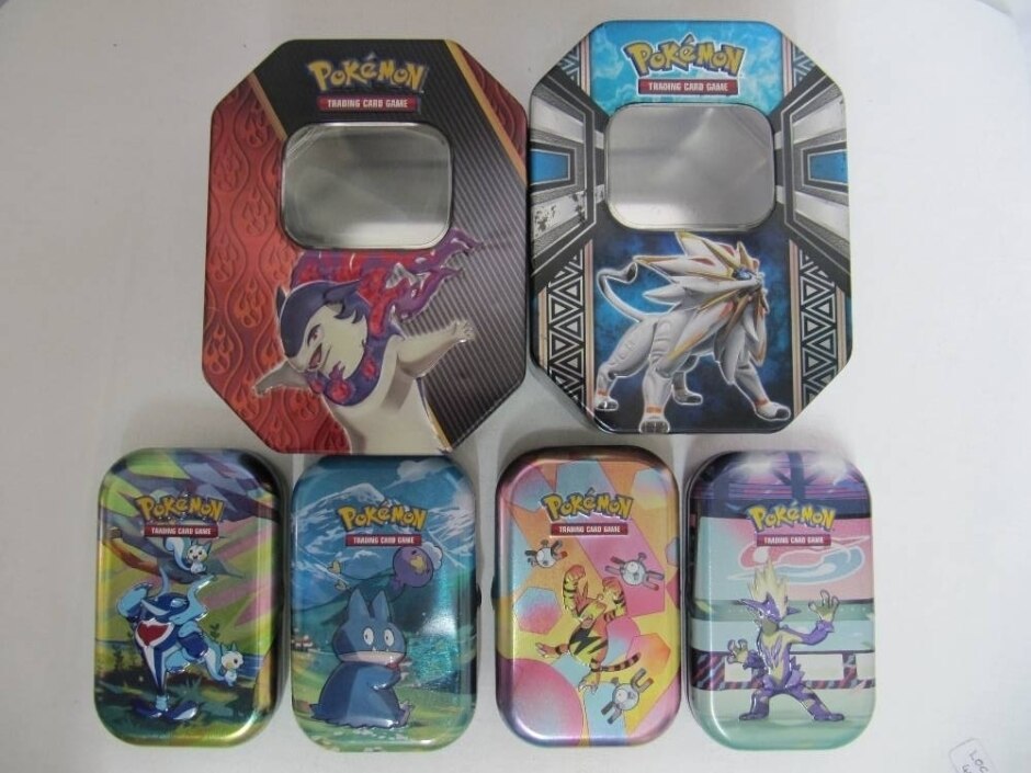 Two Large Pokémon Storage Tins Plus Four Smaller Tins To Store Pokémon Trading Cards.